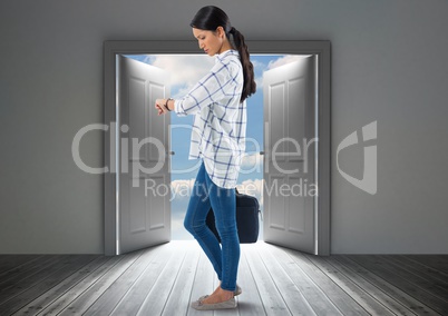 Businesswoman looking at time with briefcase by door