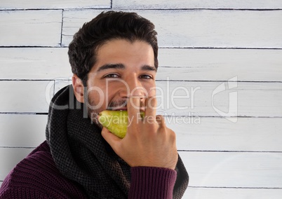 Man against wood with pear and warm scarf