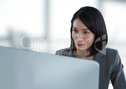 Businesswoman at desk with computer with bright background