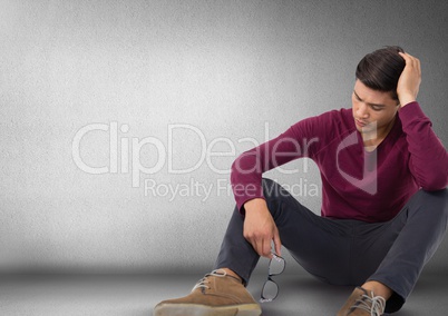 Man depressed and upset witting on floor with glasses and darkness