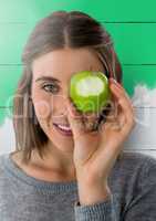 Woman against wood with apple over eye