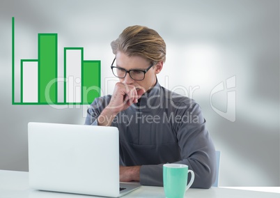 Businessman at desk with laptop and bar chart