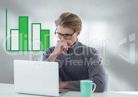 Businessman at desk with laptop and bar chart