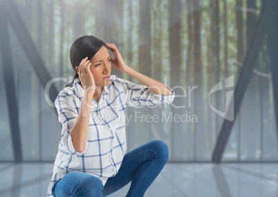 Woman holding head by forest windows