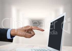 Hand pointing at laptop with bright background