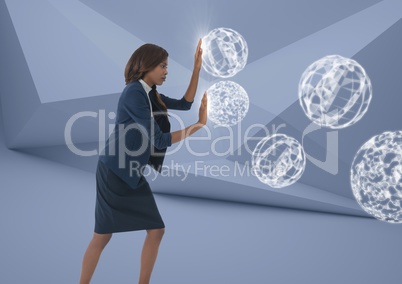 Businesswoman touching 3D orb spheres in minimal room