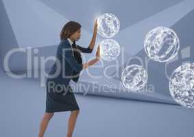 Businesswoman touching 3D orb spheres in minimal room