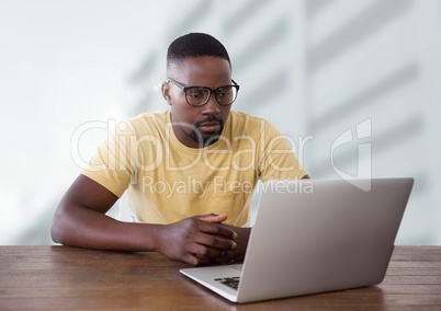 Businessman at desk with laptop with bright background