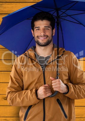 Man against wood with umbrella and coat