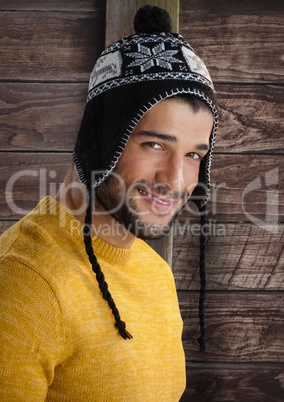 Man against wood with warm hat and jumper