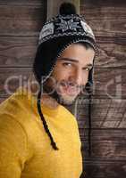 Man against wood with warm hat and jumper