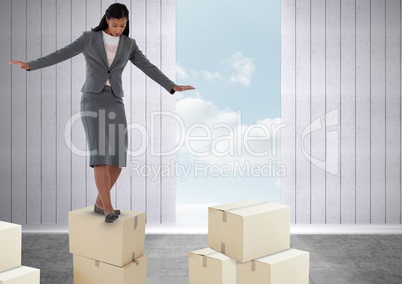 Businesswoman balancing on boxes