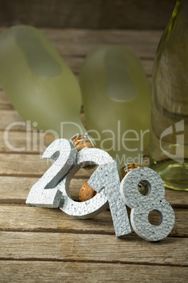 New year number 2018 and champagne bottles arranged on wooden surface