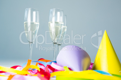 Champagne flutes with party hat and streamers