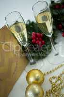 Champagne flute and christmas decoration against white background