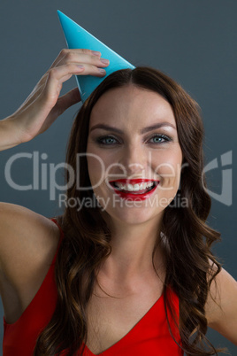 Woman wearing party hat against black background