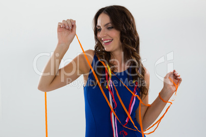 Woman wrapped in multi color streamers posing against white background