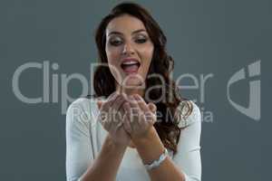 Surprised woman standing and looking into her cupped hands