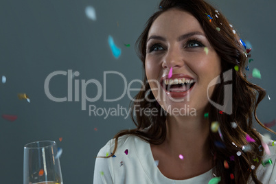 Woman celebrating the New year with falling confetti and champagne