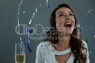 Woman celebrating the New year with falling streamers and champagne