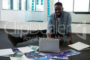 Portrait of male executive using laptop