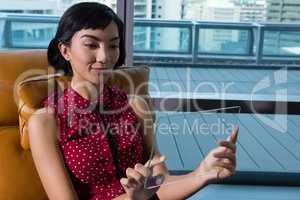 Female executive using glass digital tablet