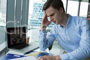 Depressed male executive sitting at desk