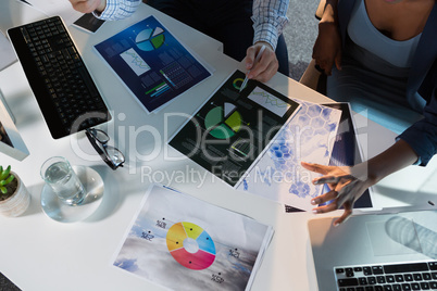 Overhead of executives discussing over graph at desk