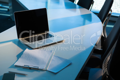 Laptop and clipboard on table