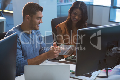 Business executives discussing over glass digital tablet