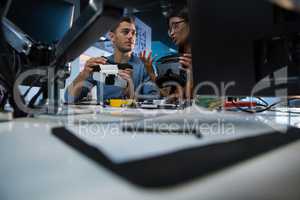 Computer engineers repairing motherboard at desk