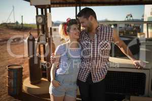 Couple standing near a car at petrol pump