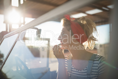 Woman applying lipstick in a car