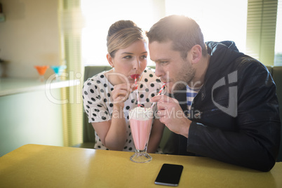 Couple having milkshake in restaurant