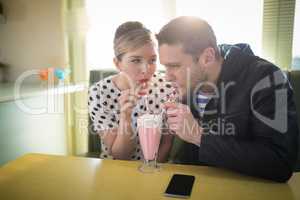 Couple having milkshake in restaurant