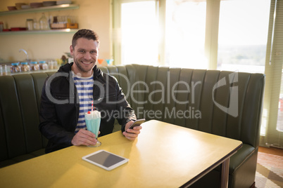 Man having milkshake in restaurant