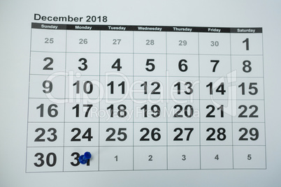 Blue pin push on day 31st of month end on white calendar