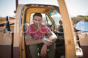 Man sitting in a car on a sunny day