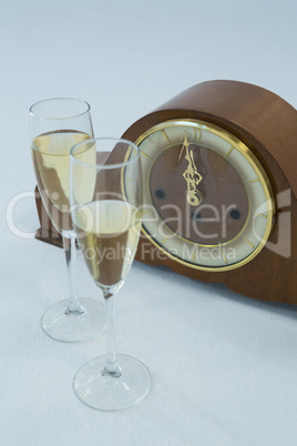 Champagne glass and clock on white background