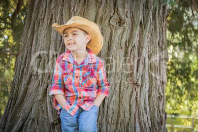 Mixed Race Young Boy Wearing Cowboy Hat Standing Outdoors.