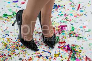 Woman standing wearing black heels standing on the confetties