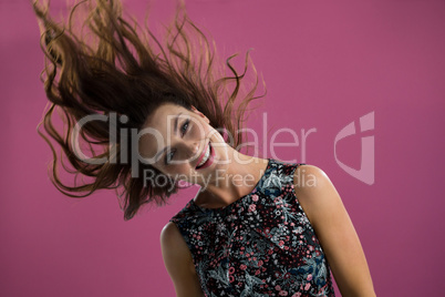 Smiling woman tossing her long hair