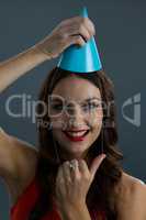 Woman wearing party hat against black background