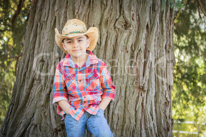 Mixed Race Young Boy Wearing Cowboy Hat Standing Outdoors.