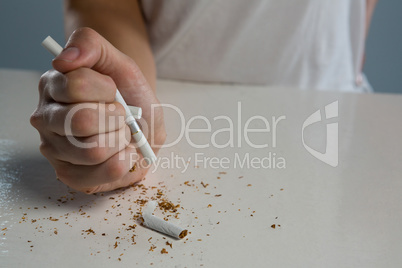 Woman breaking cigarette with fist