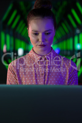 Female executive using laptop in futuristic office