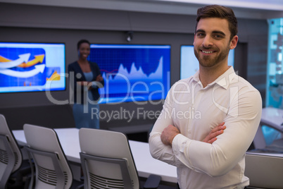 Male and female executives standing in boardroom