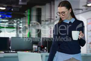 Female executive using laptop while having coffee