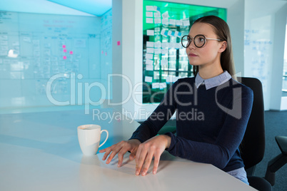 Female executive gesturing at desk