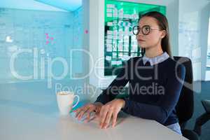 Female executive gesturing at desk